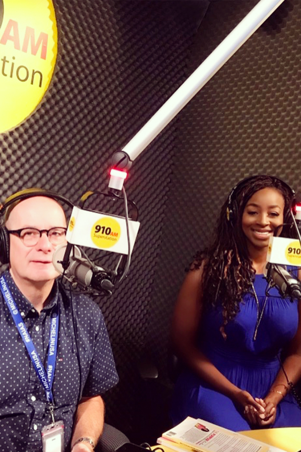 Two people sitting in front of a microphone in a radio studio.