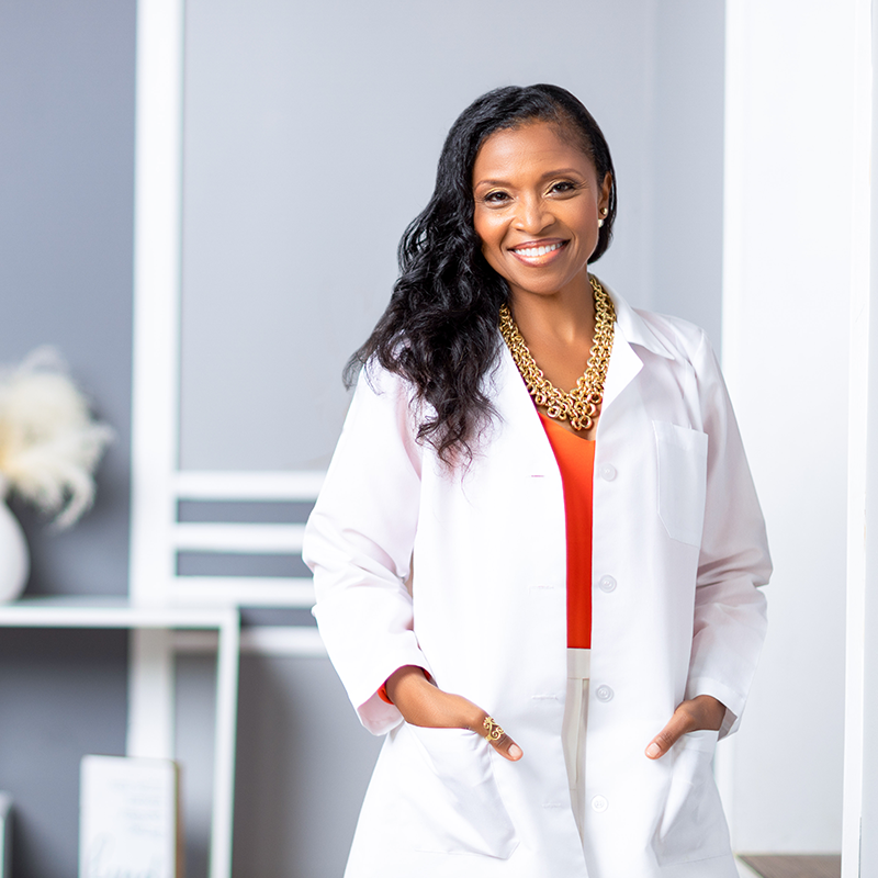 A woman in a white lab coat standing in a room. A woman in a white lab coat standing in a room.